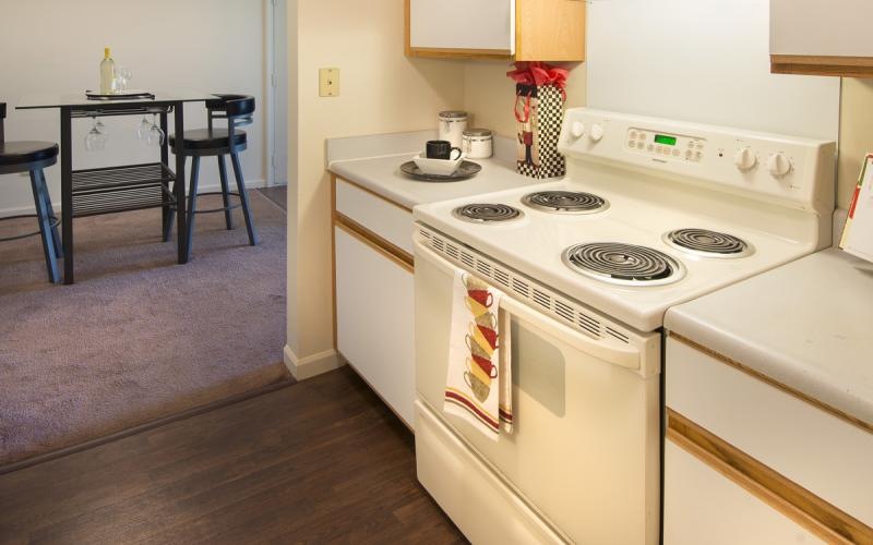 a kitchen with a white stove and white cabinets