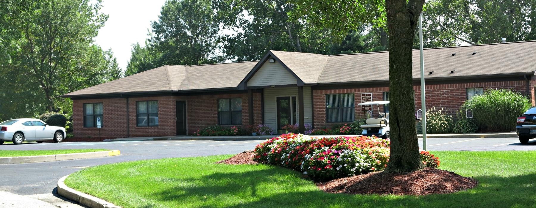 a large house with a lawn and trees in front of it